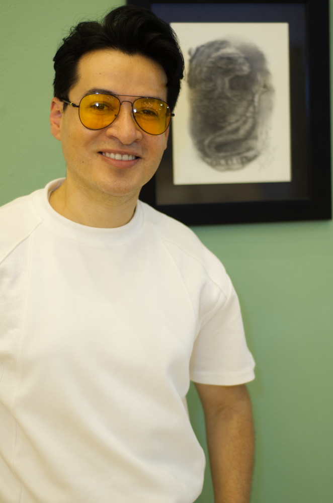 Un primer plano del artista Alejandro Londoño, junto a su obra "Voilà" en la exposición del gran salón BAT, en la cámara de comercio de Medellín.