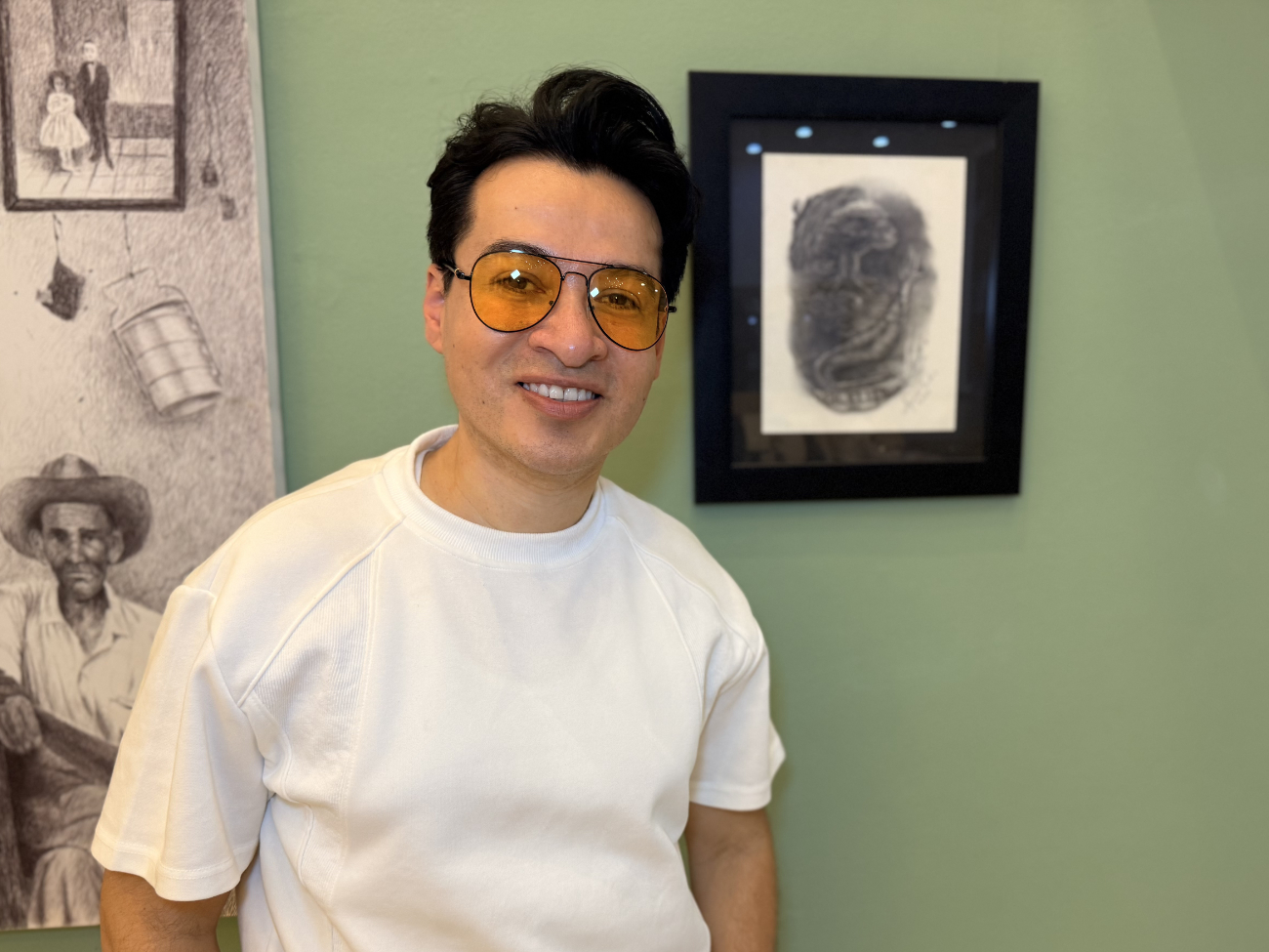 El artista Alejandro Londoño posando junto a su obra "Voilà" en la exposición del salón BAT, en Medellín